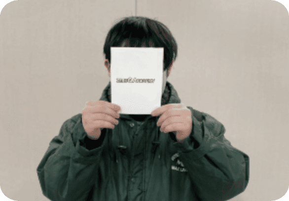 ゼルクアカデミーの書類を正面に持った男性の画像